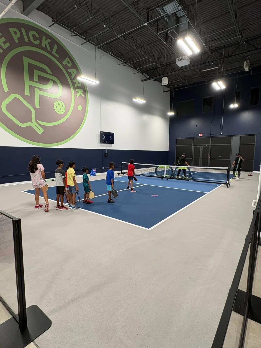 Young players gathered beside indoor courts at Pickl Park