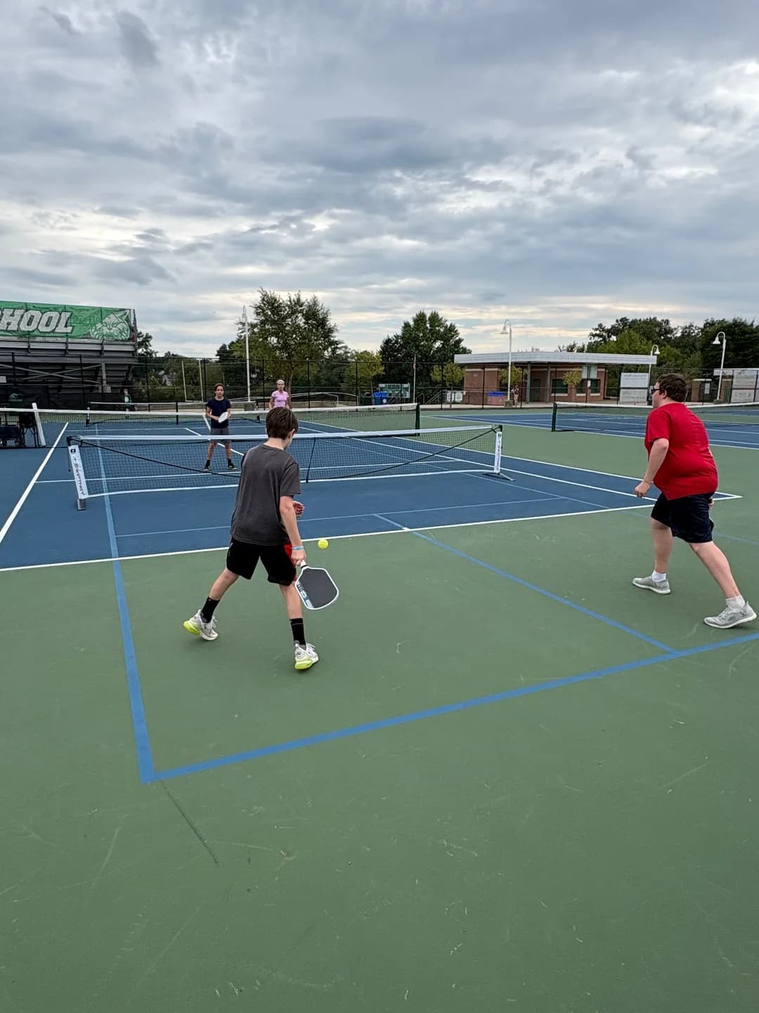 Young players rallying across portable pickleball nets outdoors