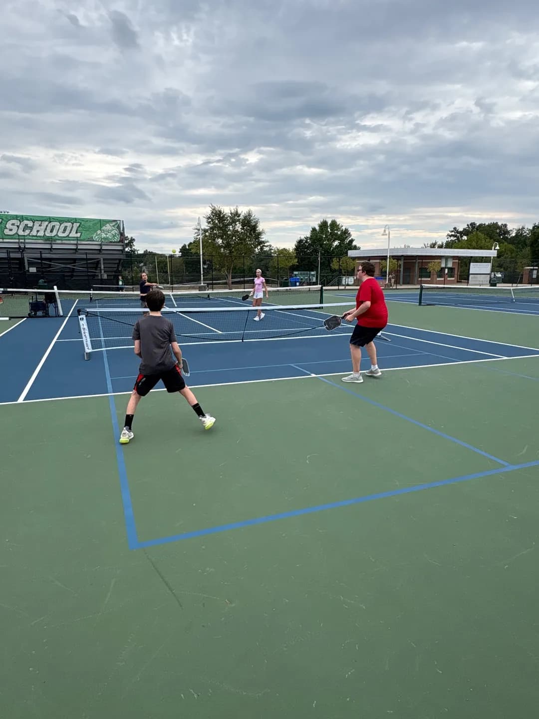 Young players rallying across portable pickleball nets outdoors