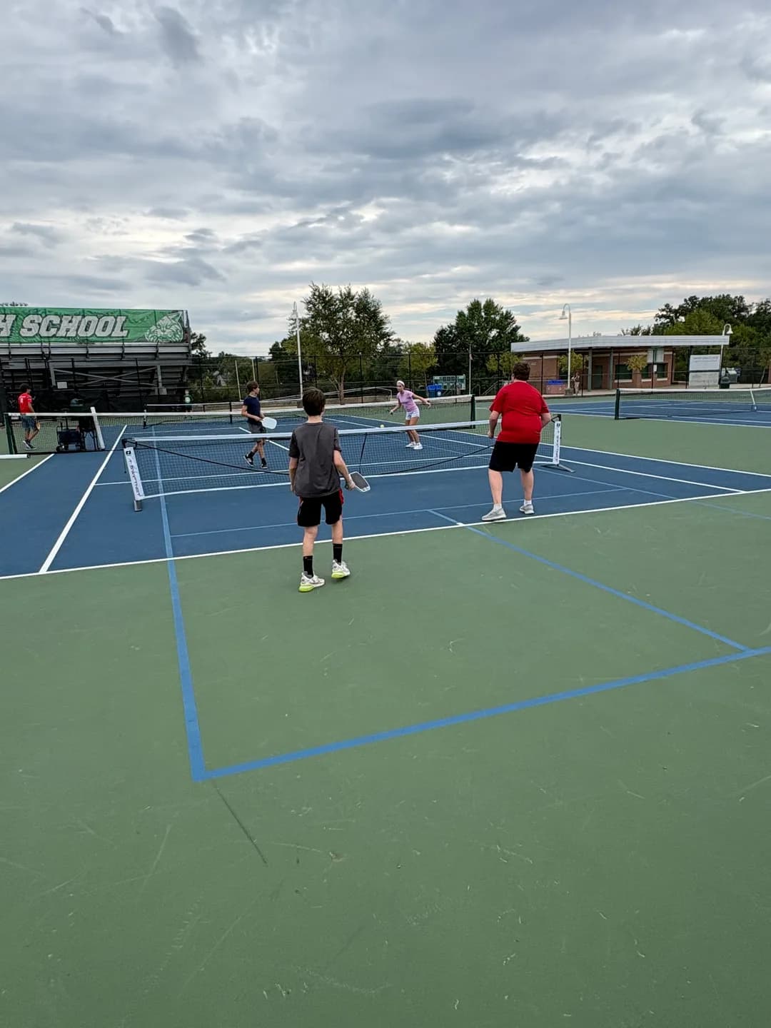 Young players rallying across portable pickleball nets outdoors