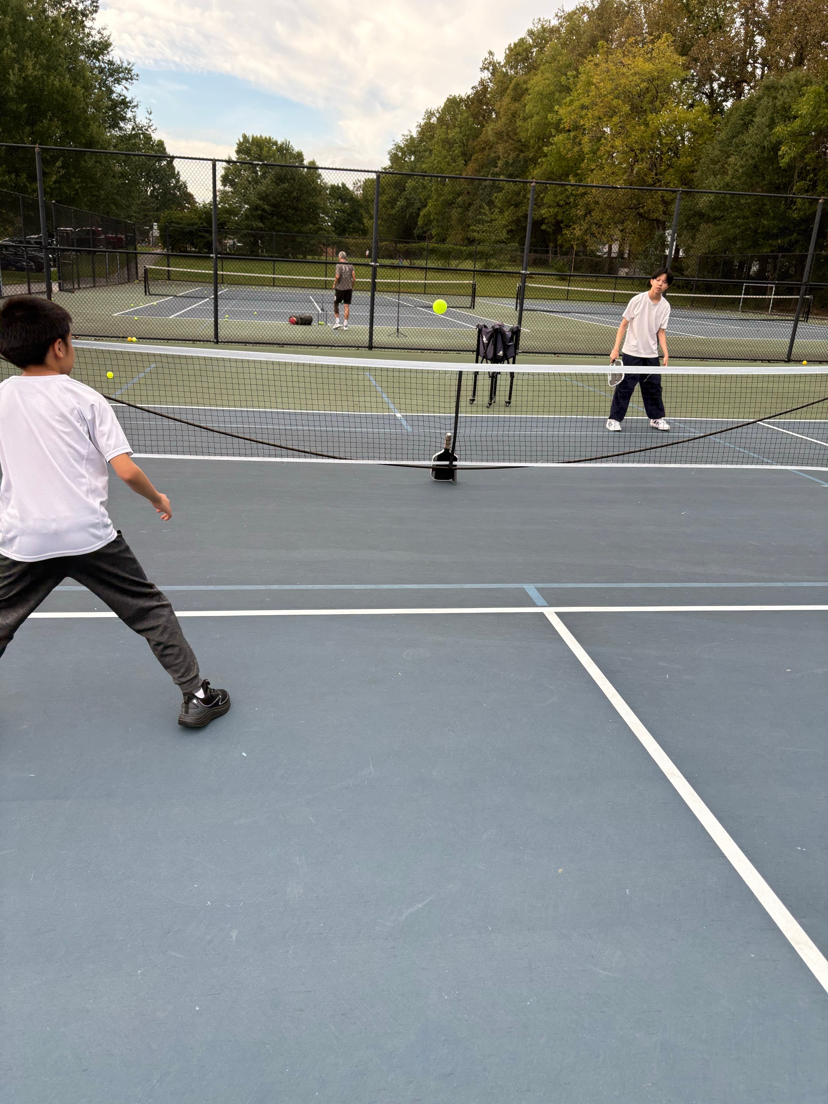 Two players exchanging shots on an outdoor court